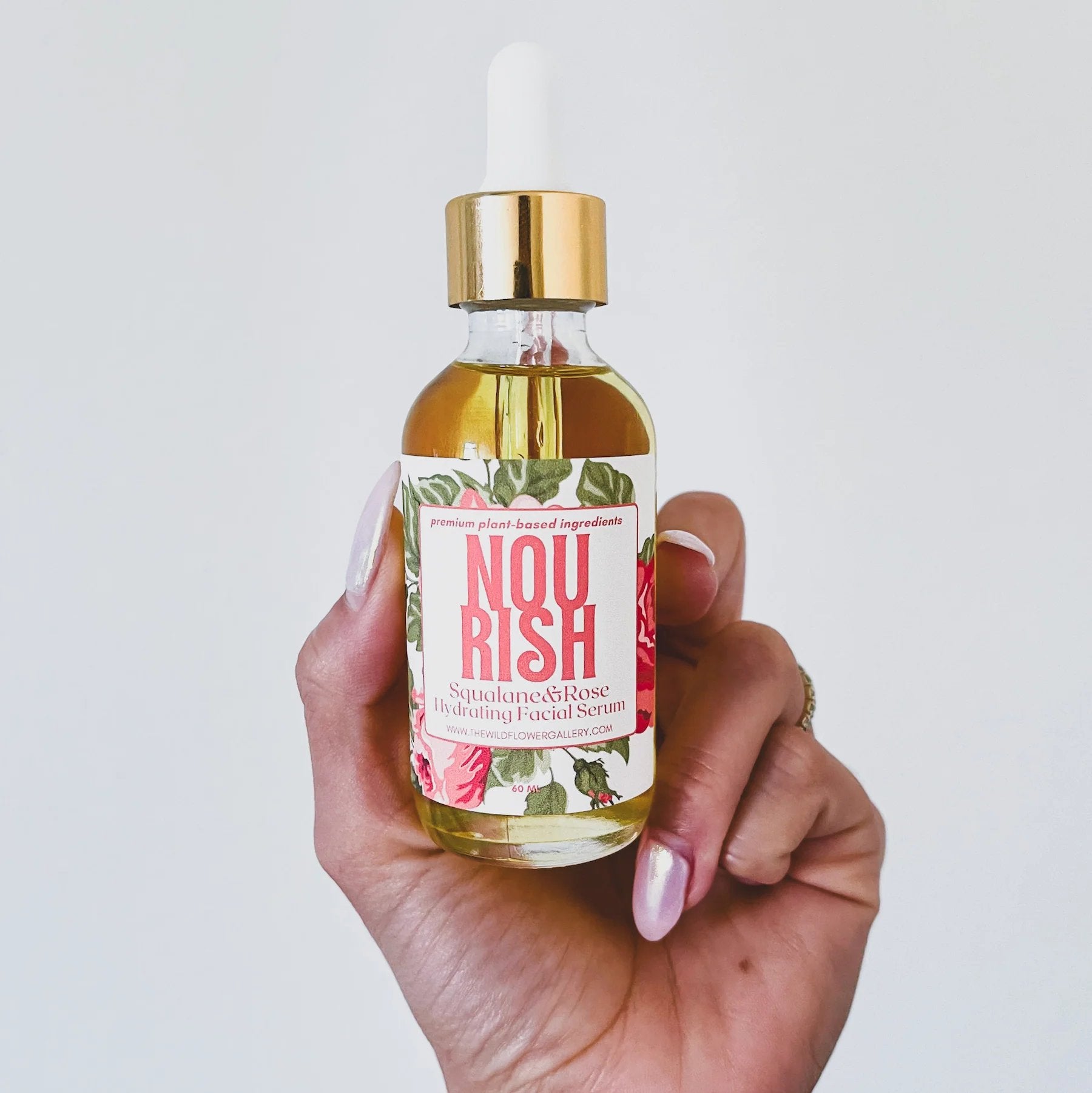 Applying Nourish Facial Serum to cheek – lightweight, fast-absorbing anti-aging serum made with organic ingredients for glowing, balanced skin.