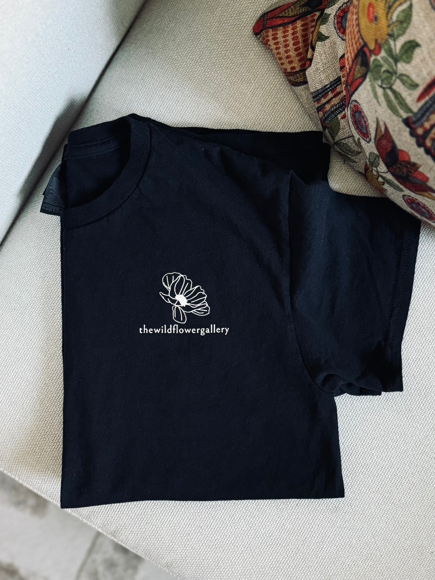 White organic cotton and bamboo T-shirt featuring The Wildflower Gallery logo on front left chest – breathable, handprinted, and ethically made.