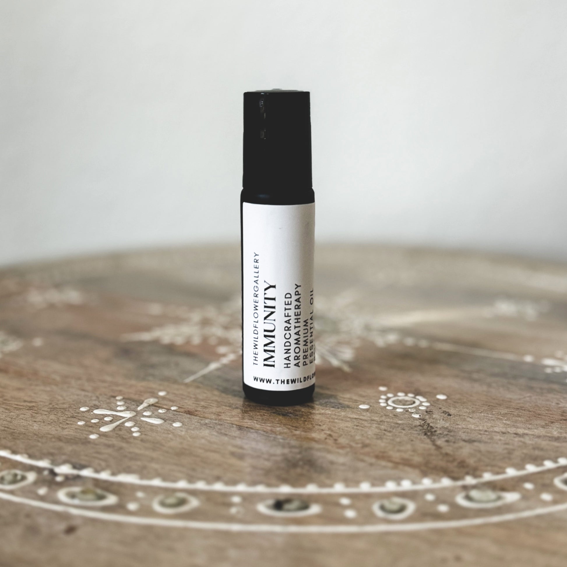 Immunity essential oil roll-on with cinnamon, clove, and lemon – wellness aromatherapy blend in eco-friendly black roller bottle.