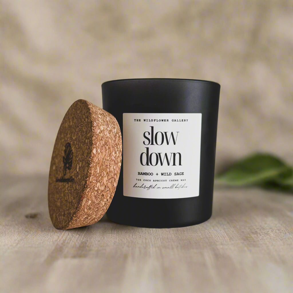Slow Down candle with bamboo & wild sage scent in a black matte recycled glass jar with cork lid – non-toxic, clean-burning, handcrafted coconut apricot wax candle.