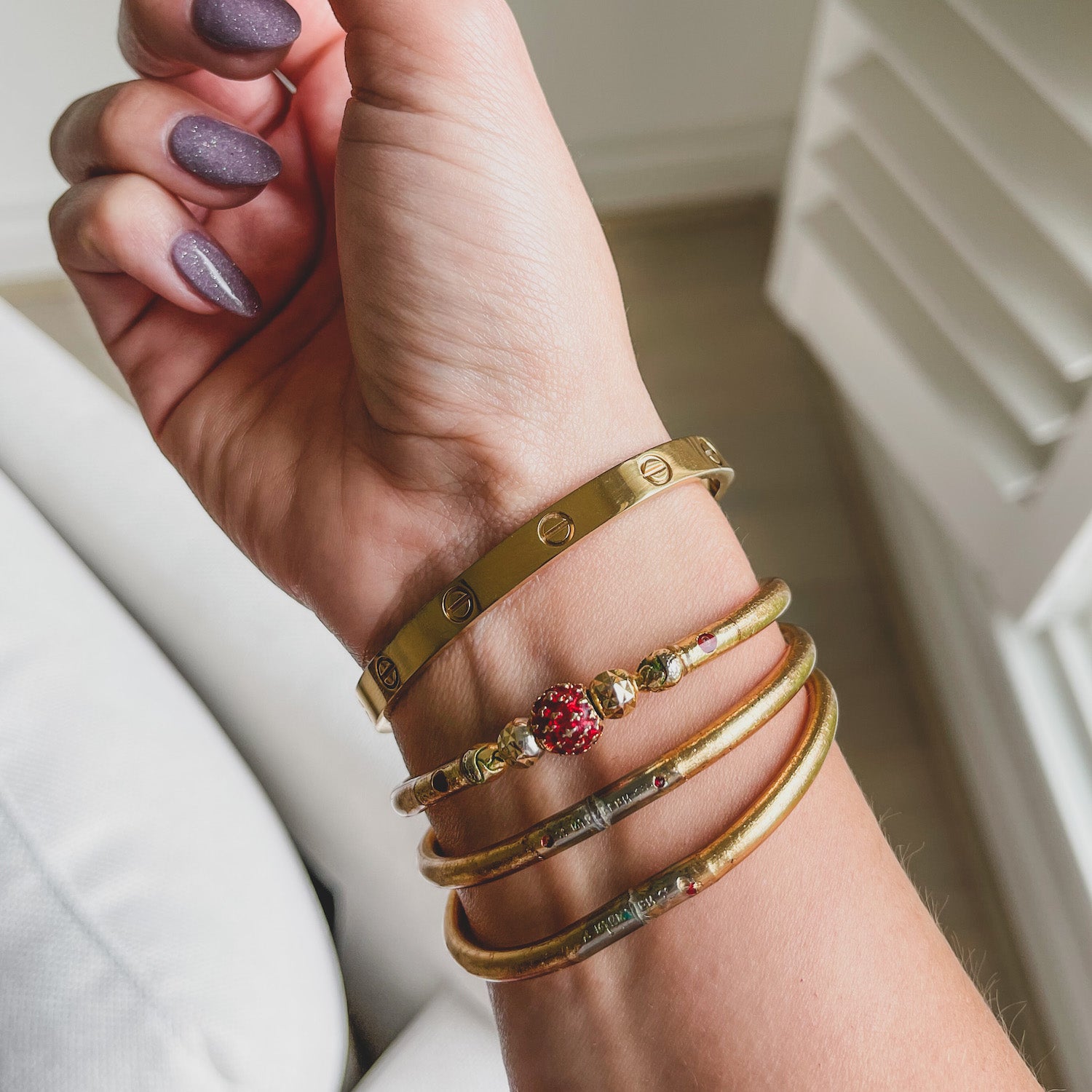 wrist wearing authentic buddha bangles in gold handmade in thailand