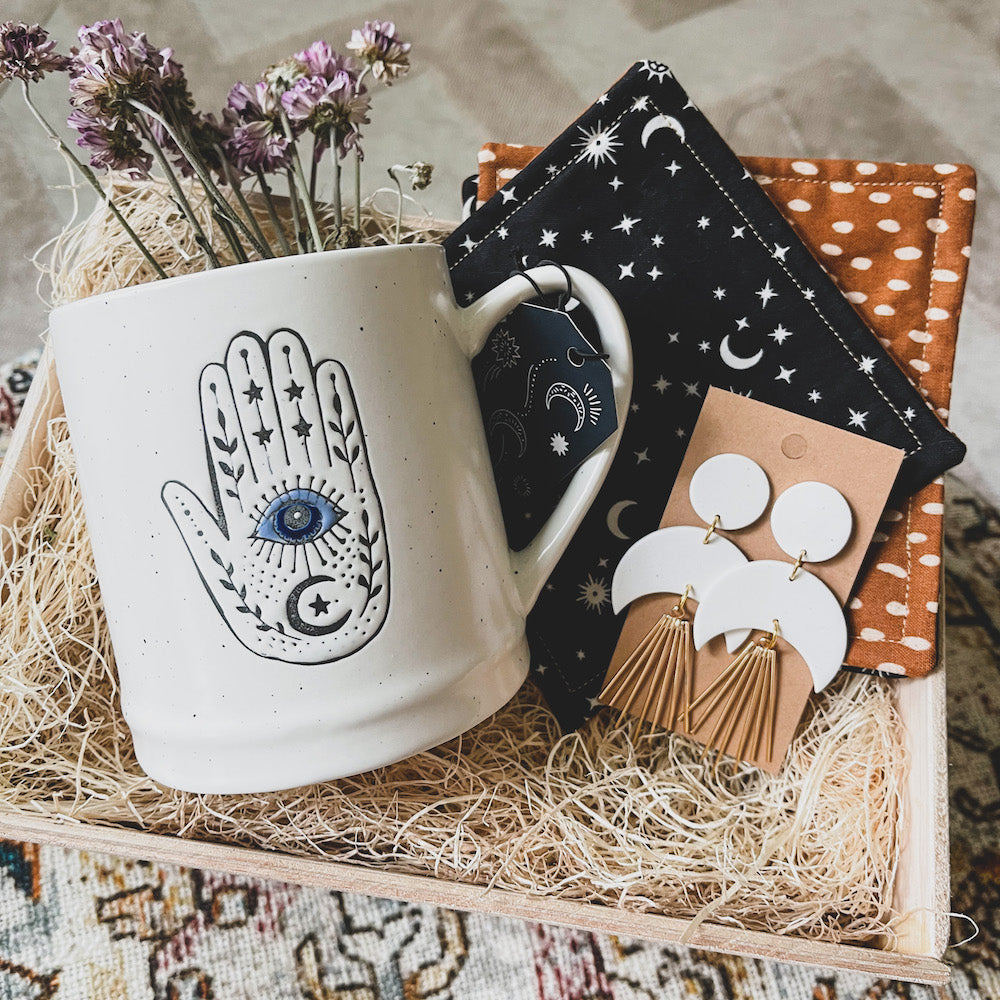 personalized handcrafted custom gift boxes with evil eye hamsa hand white coffee mug and white half moon clay earrings. The perfect gift for that spiritual friend.