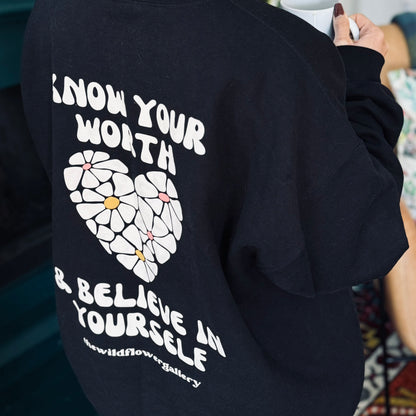 Black eco-friendly crewneck sweatshirt with “you are enough” handprinted text – made from organic cotton and recycled polyester, modeled in medium unisex fit.