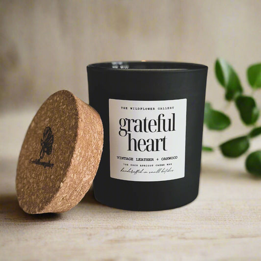 Grateful Heart candle with vintage leather & oakwood scent in a black matte recycled glass jar with cork lid – non-toxic, clean-burning, handcrafted coconut apricot wax candle.
