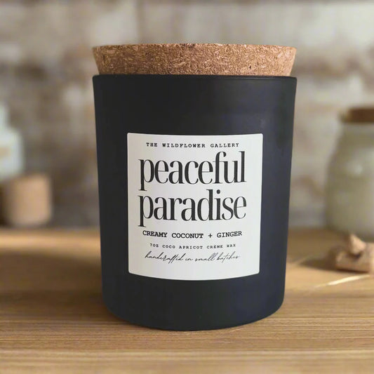 Peaceful Paradise candle with creamy coconut & ginger scent in a black matte recycled glass jar with cork lid – non-toxic, clean-burning, handcrafted coconut apricot wax candle.