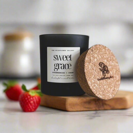 Sweet Grace candle with strawberries & cream scent in a black matte recycled glass jar with cork lid – non-toxic, clean-burning, handcrafted coconut apricot wax candle.