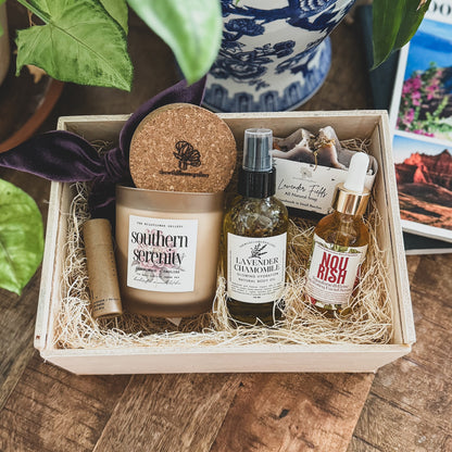 Ultimate Self-Care Gift Box featuring a non-toxic candle, natural skincare, lavender vanilla lip balm, velvet scrunchie, and glowing body oil in a wooden keepsake box.