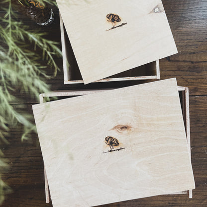 Handcrafted wooden gift box filled with wellness products, wood shavings, and dried flowers – elegant packaging for personalized self-care or special occasions.